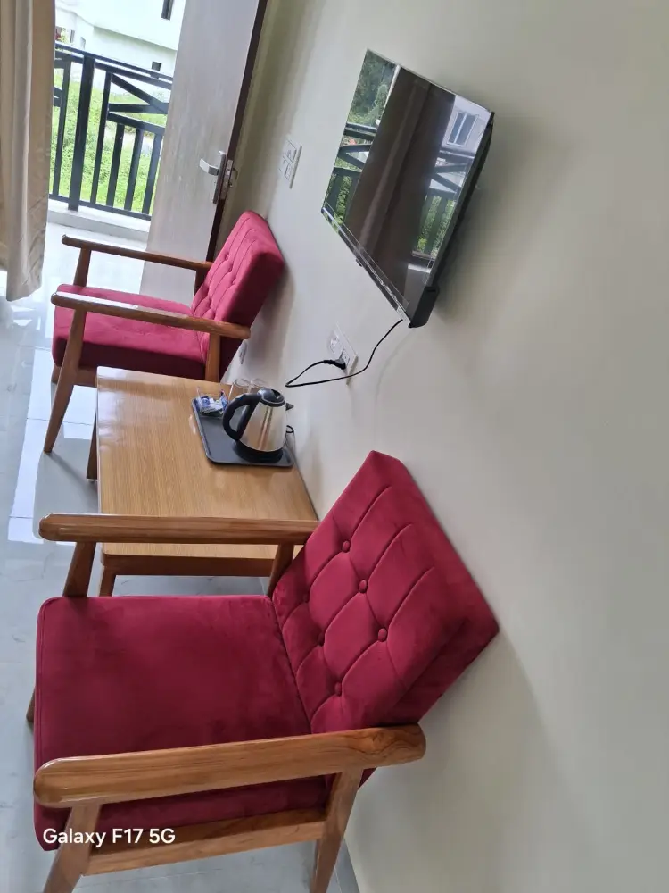 Two cushioned armchairs and a wooden table with a tea tray in the room