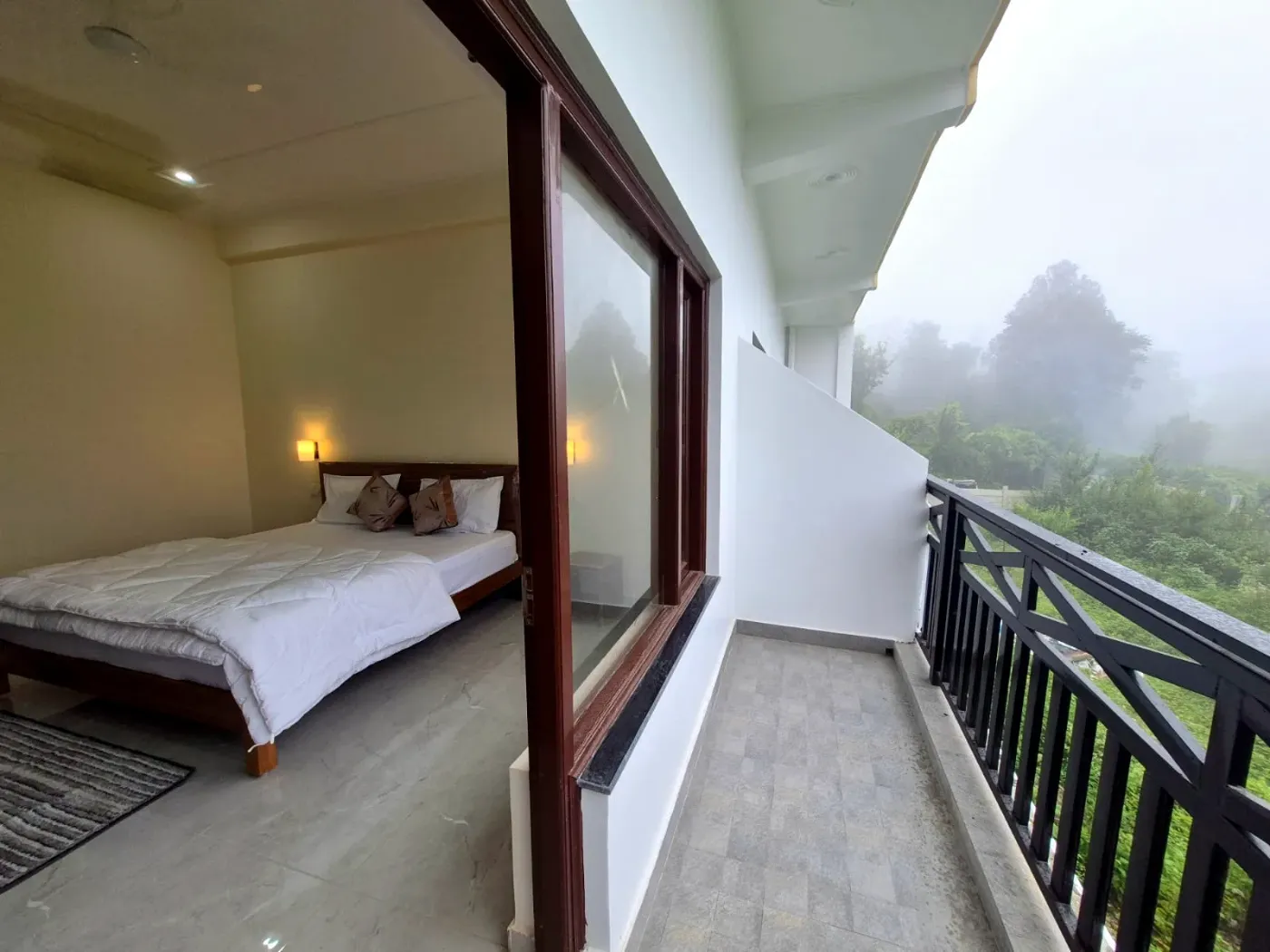 King bed beside an open sliding door to a private balcony